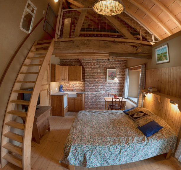 Schlafzimmer mit Holztreppe und Balkenkonstruktion