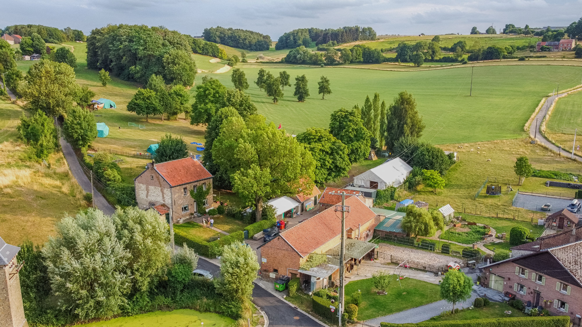 Aerial view of De Drink with a camping site on the rolling green hills of the Voer region.