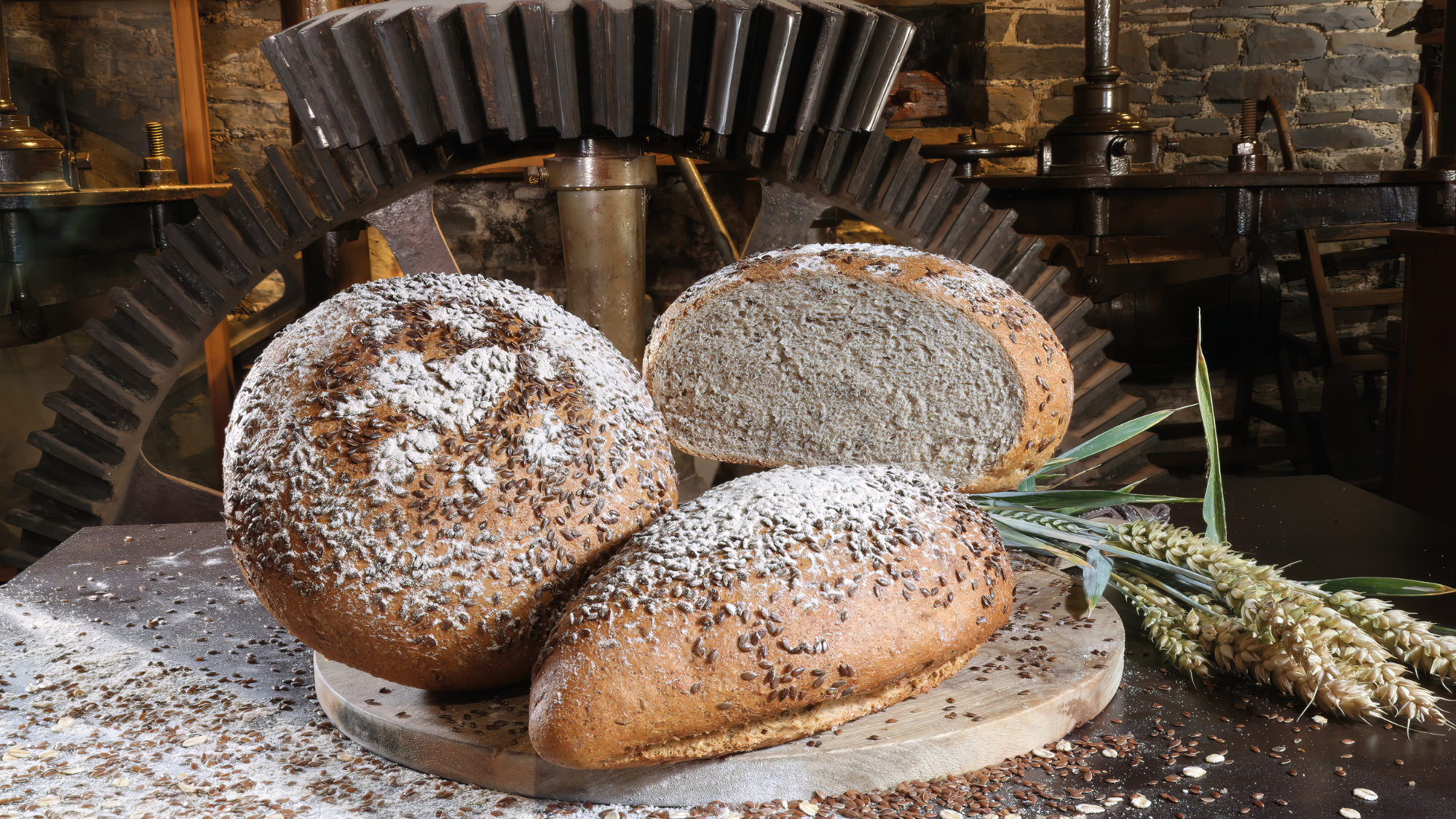 Gcorn mill with delicious artisan breads on the millstone
