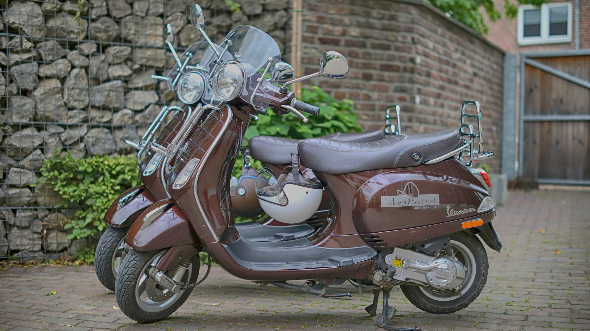 Scooter parked in front of the Laken & Servet house with the logo on it.