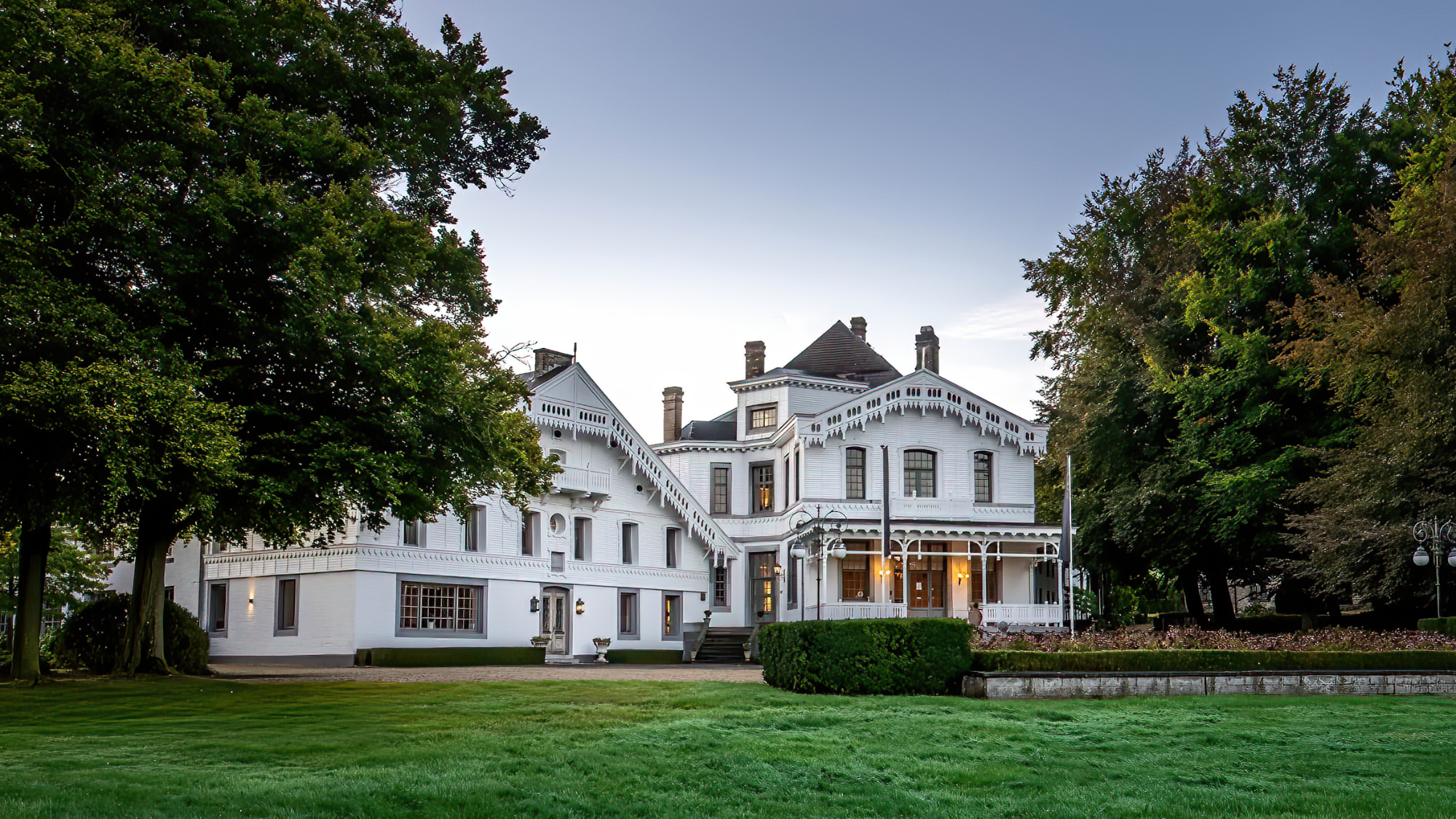 Front view of Estate Altenbroek with lots of greenery around it.