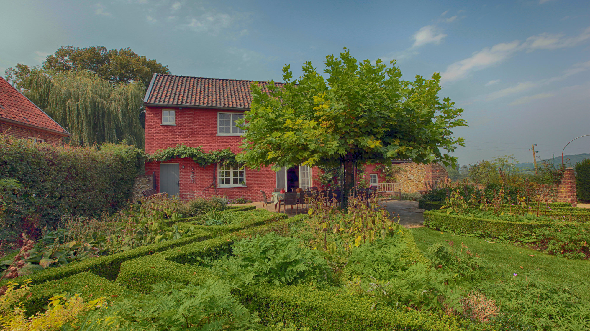 Das Landhaus Pietershof vom Garten aus gesehen mit viel Grün.