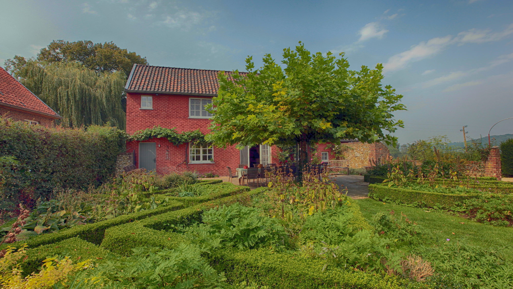 Het Landhuis Pietershof vanuit de tuin bekeken met zeer veel groen.