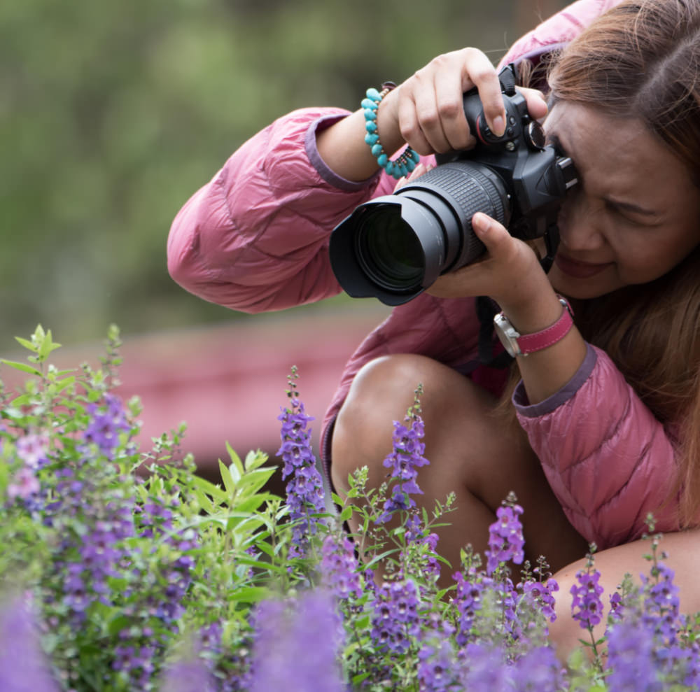 Female photographer takes picture of flower