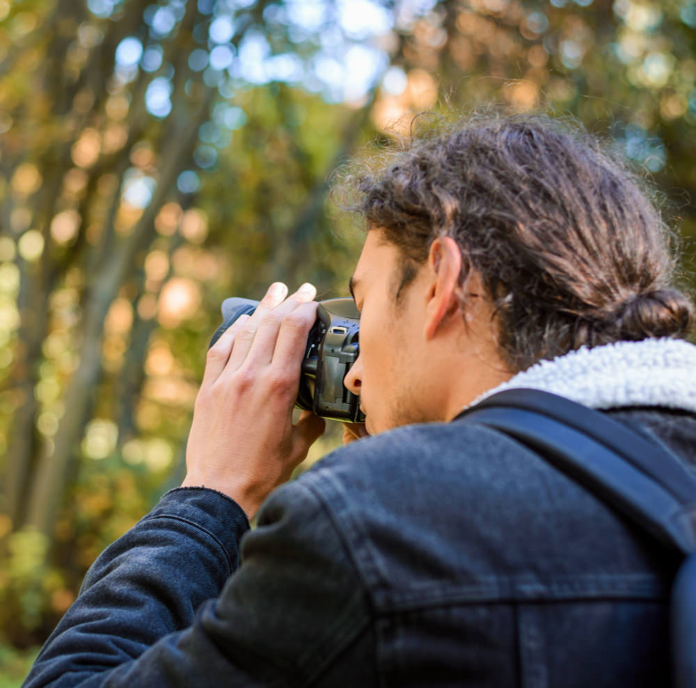 Manlijke fotograaf maakt foto van de natuur