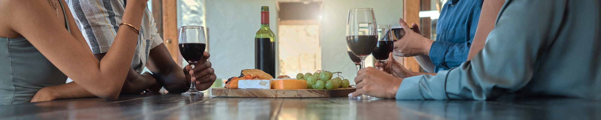 4 personnes à table dans un restaurant avec un verre de vin rouge