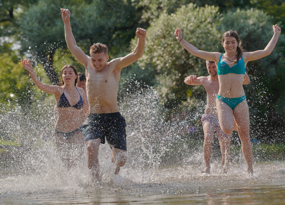 De header hero van de waterpret pagina met 4 jongens en meisjes die door het water rennen